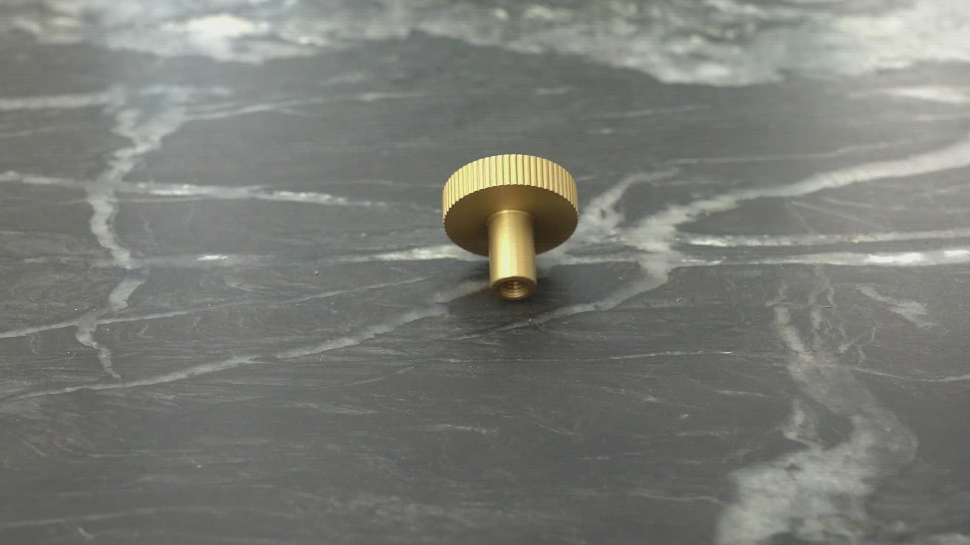 Video af rund møbelknop i massiv messing med linjeret design på kanten
