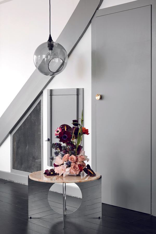 Rund lampe i smoked glas og med et afskåret stykke med kig til pæren. Fatningen og rosetten er sort og ledningen er af sort stof.