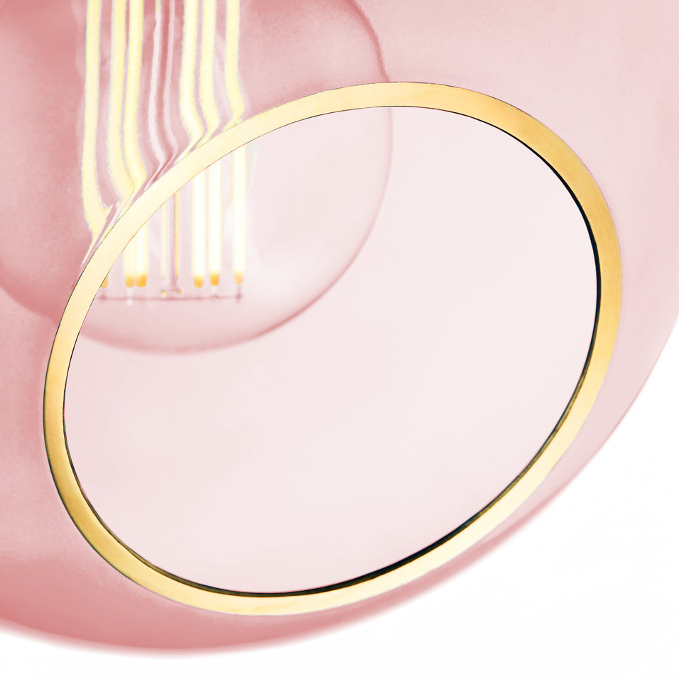 Rund lampe i rosafarvet glas med et afskåret stykke med guldkant. Fatning er guldfarvet og ledningen er af sort stof.