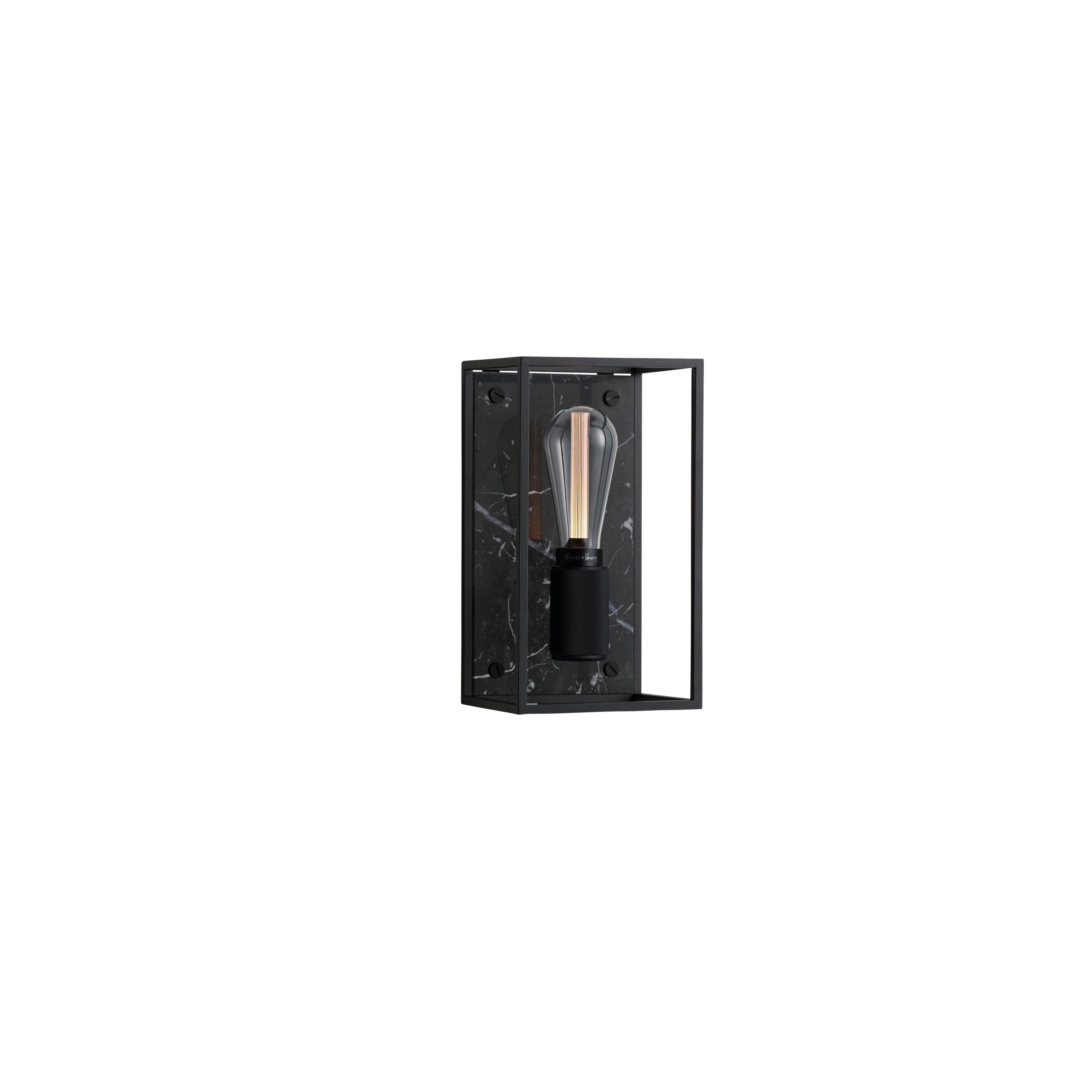 Buster and Punch caged wall lamp medium i sort metal med bagpanel i sort marmor.