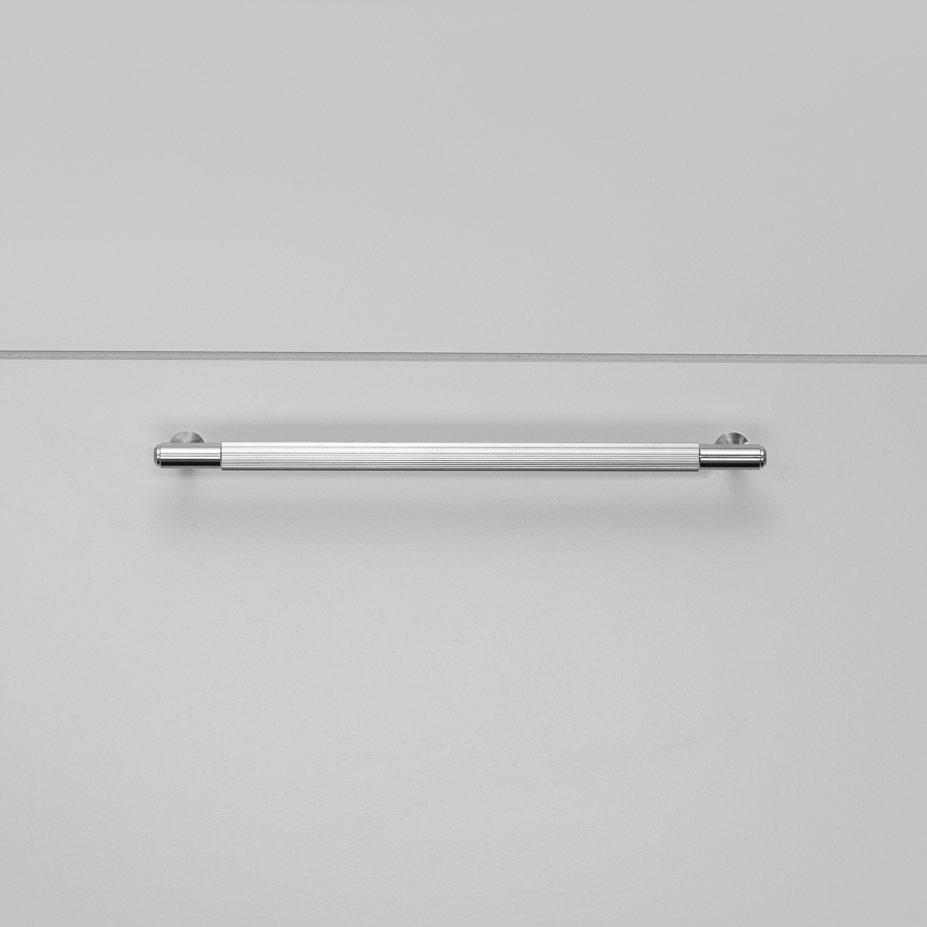 Køkkengreb til køkkenlåger fra Buster + Punch i rustfri stål med linjeret design.