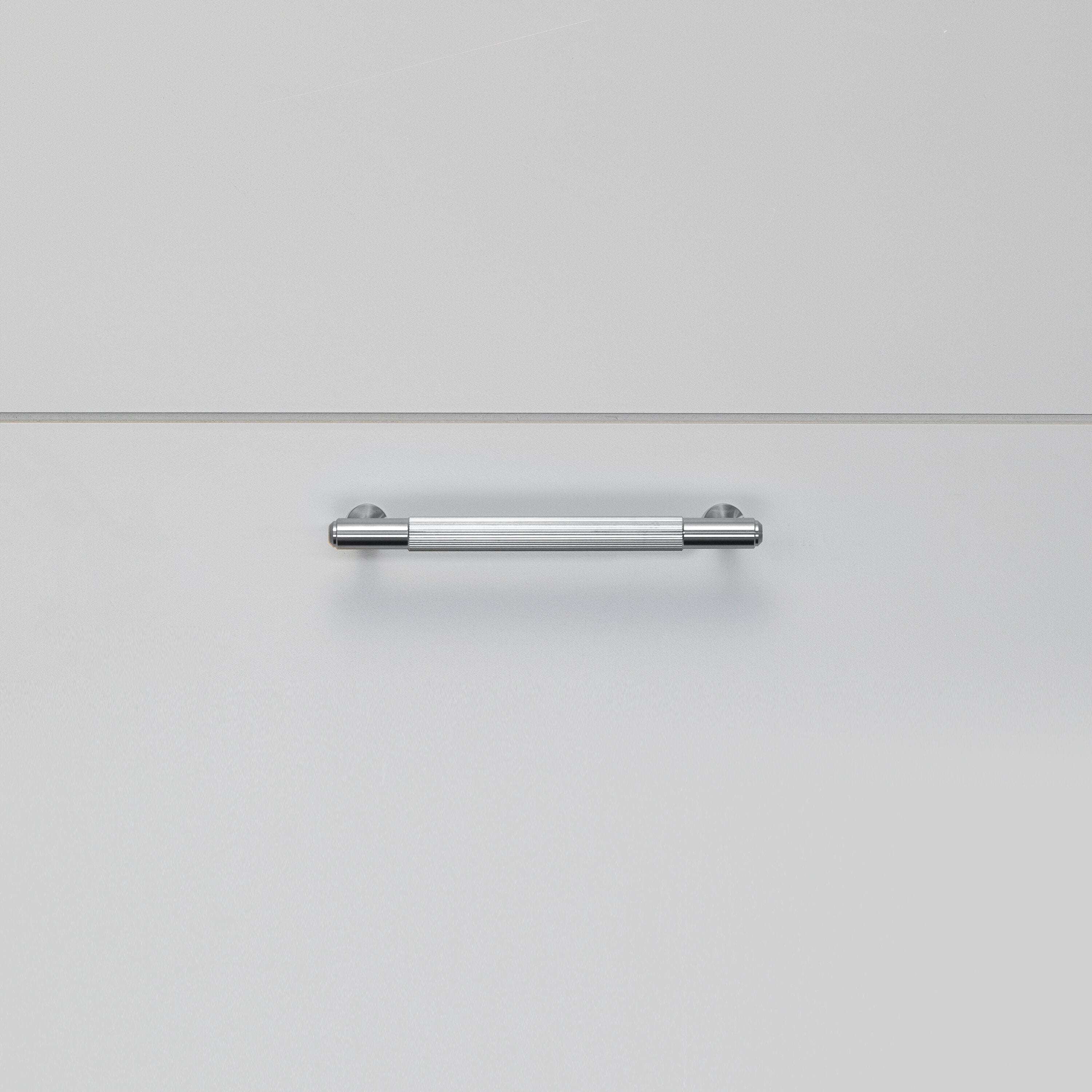 Køkkengreb til køkkenlåger fra Buster + Punch i rustfri stål med linjeret design.