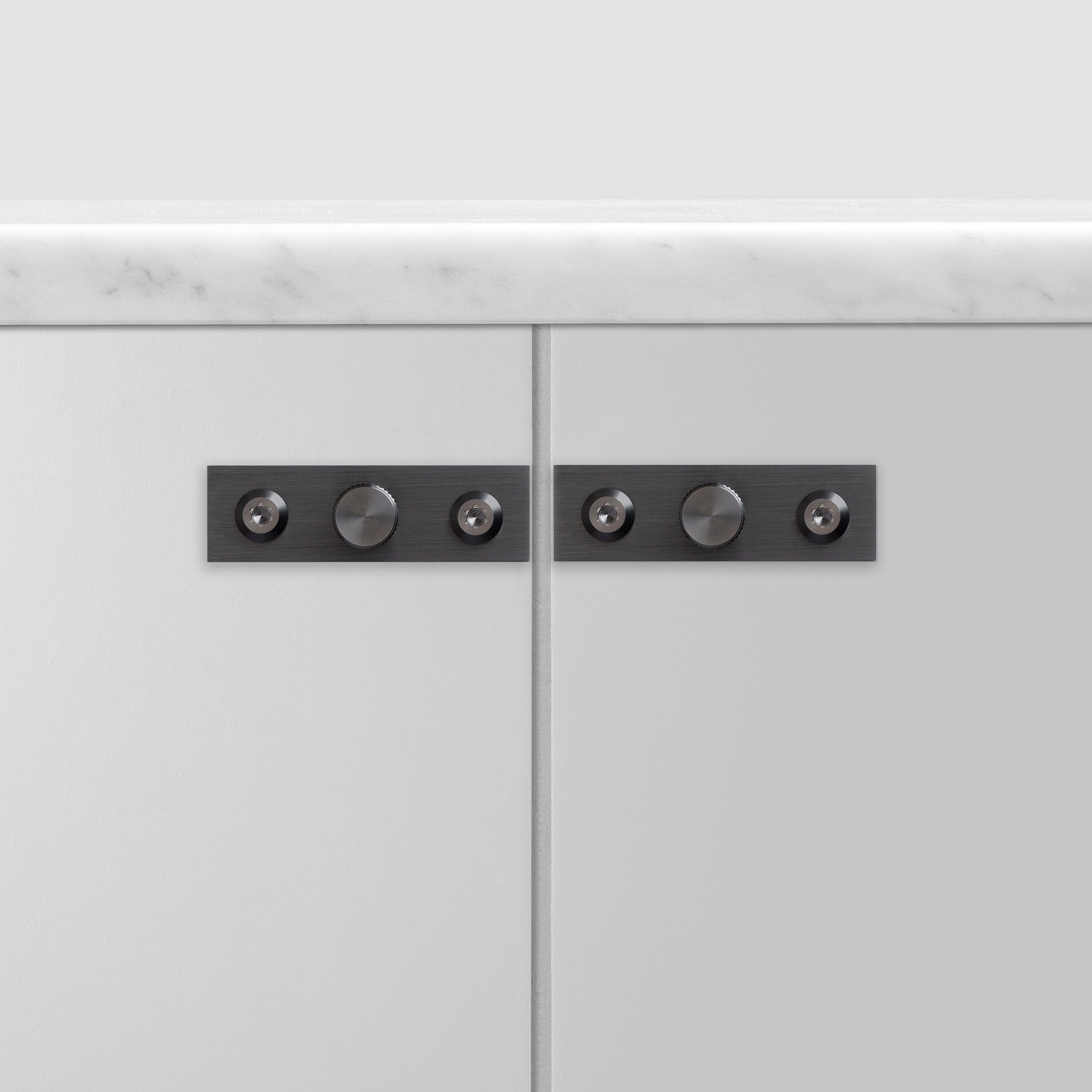 Eksklusive møbelknopper fra Buster + Punch i gun metal med linjeret mønster og bag plade