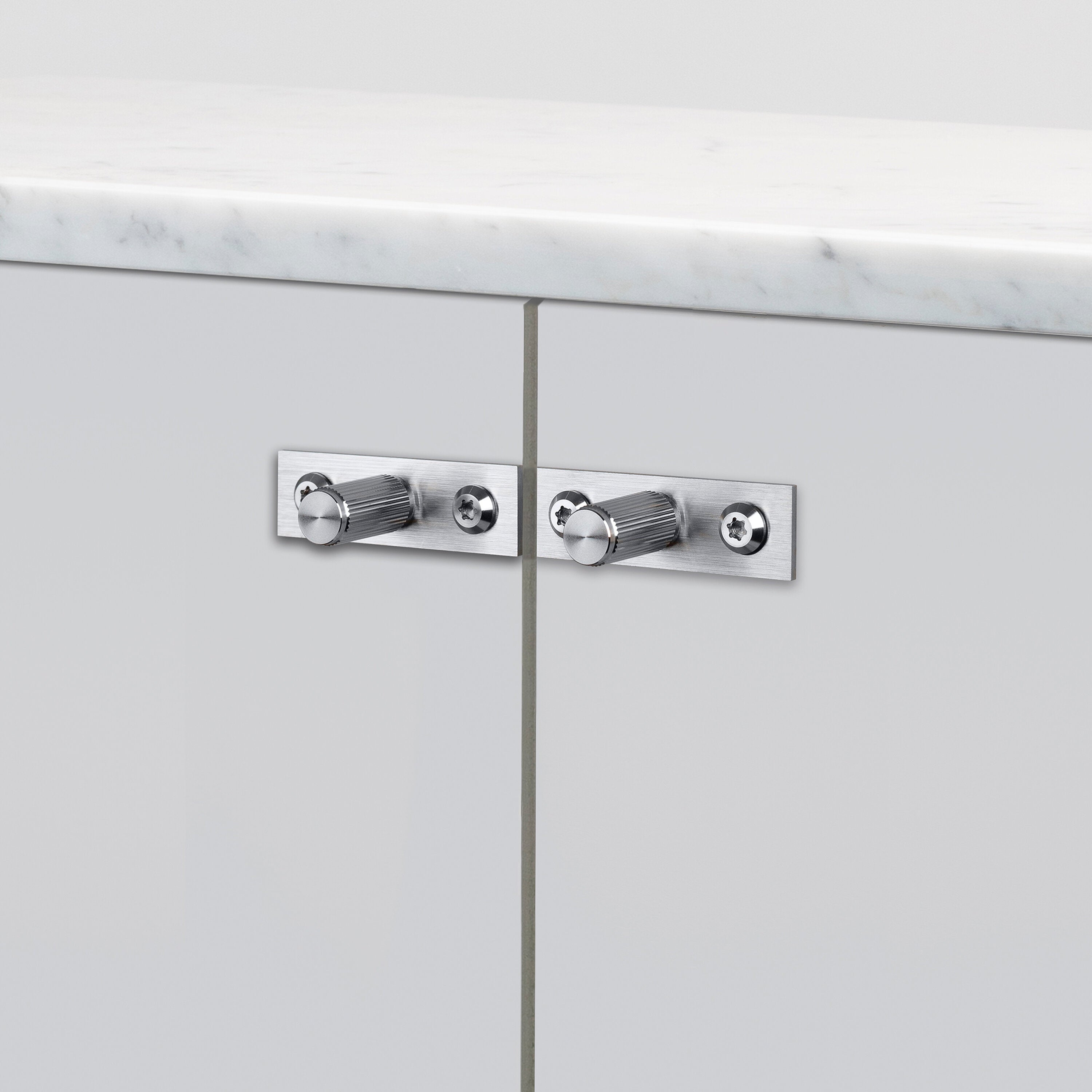 Eksklusive knopper fra Buster + Punch i rustfri stål med linjeret mønster og bag blade til dækning af gamle monteringshuller.