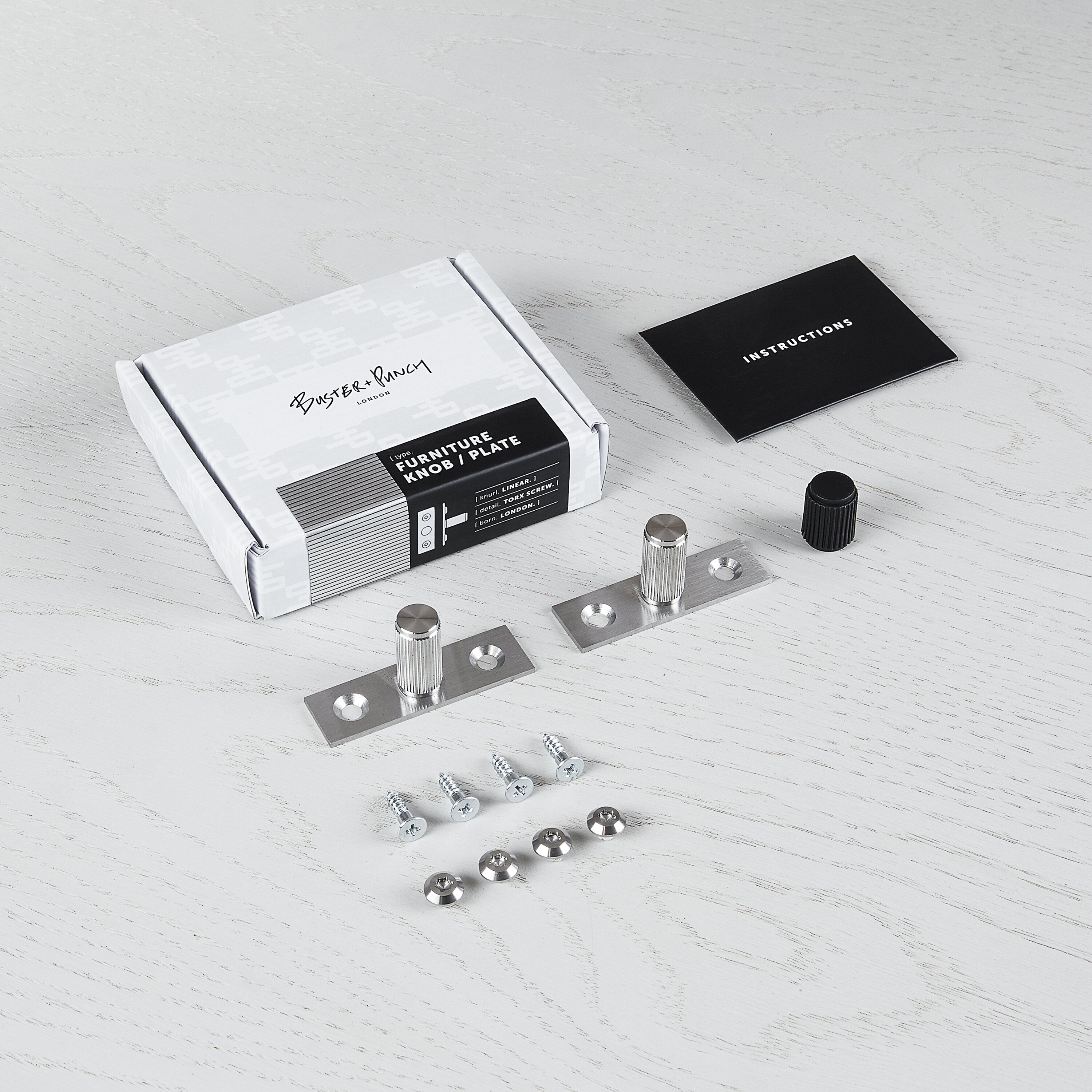 Eksklusive knopper fra Buster + Punch i rustfri stål med linjeret mønster og bag blade til dækning af gamle monteringshuller.