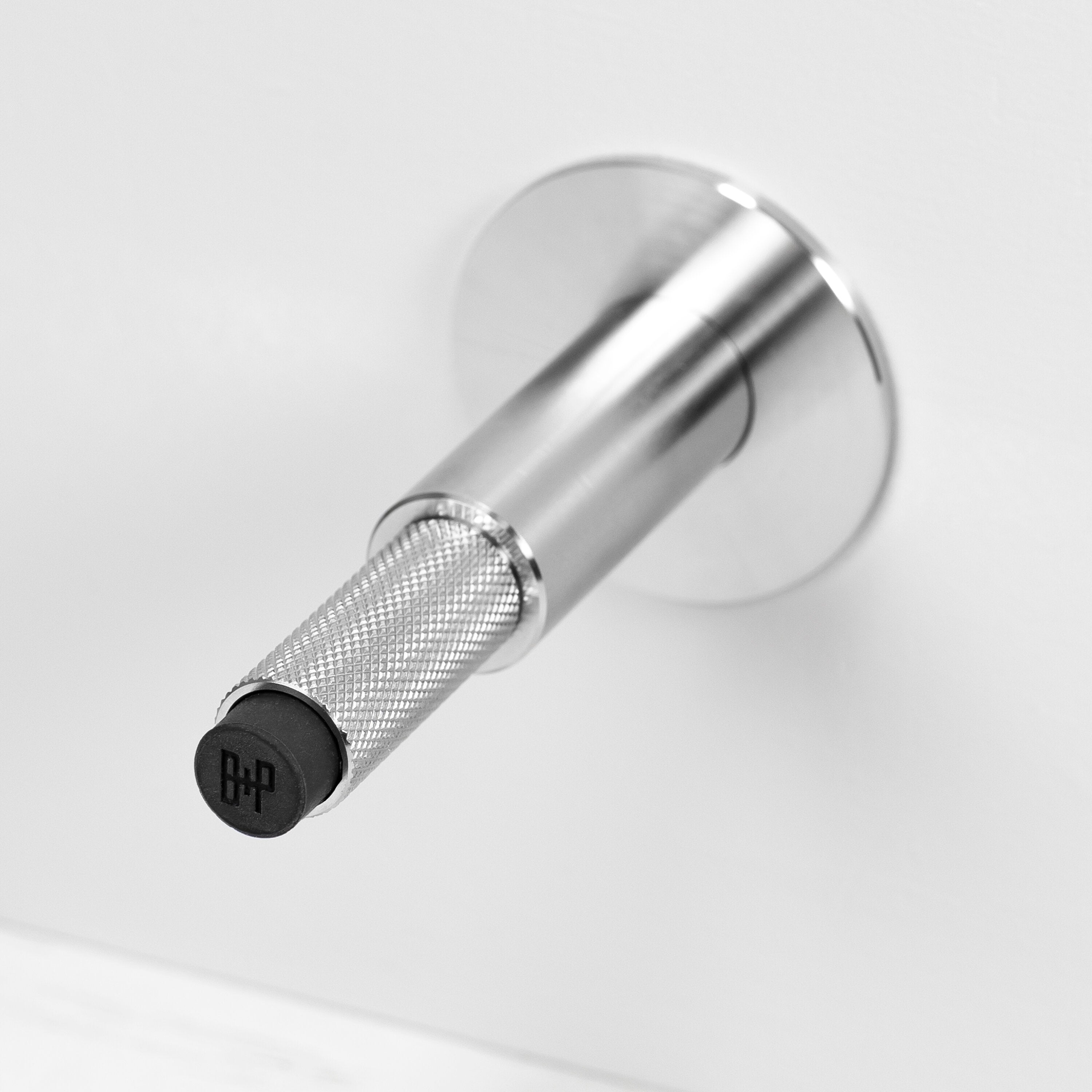 Eksklusiv dørstopper til vægmontering i massiv rustfri stål fra Buster + Punch med diamond cut (cross) mønster.