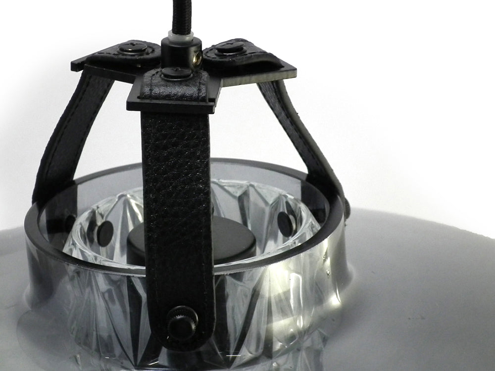 Lampen har en røgfarvet glasskærm i mundblæst glas, et facetslebet cylinderrør samt unikke detaljer i bl.a. læder.