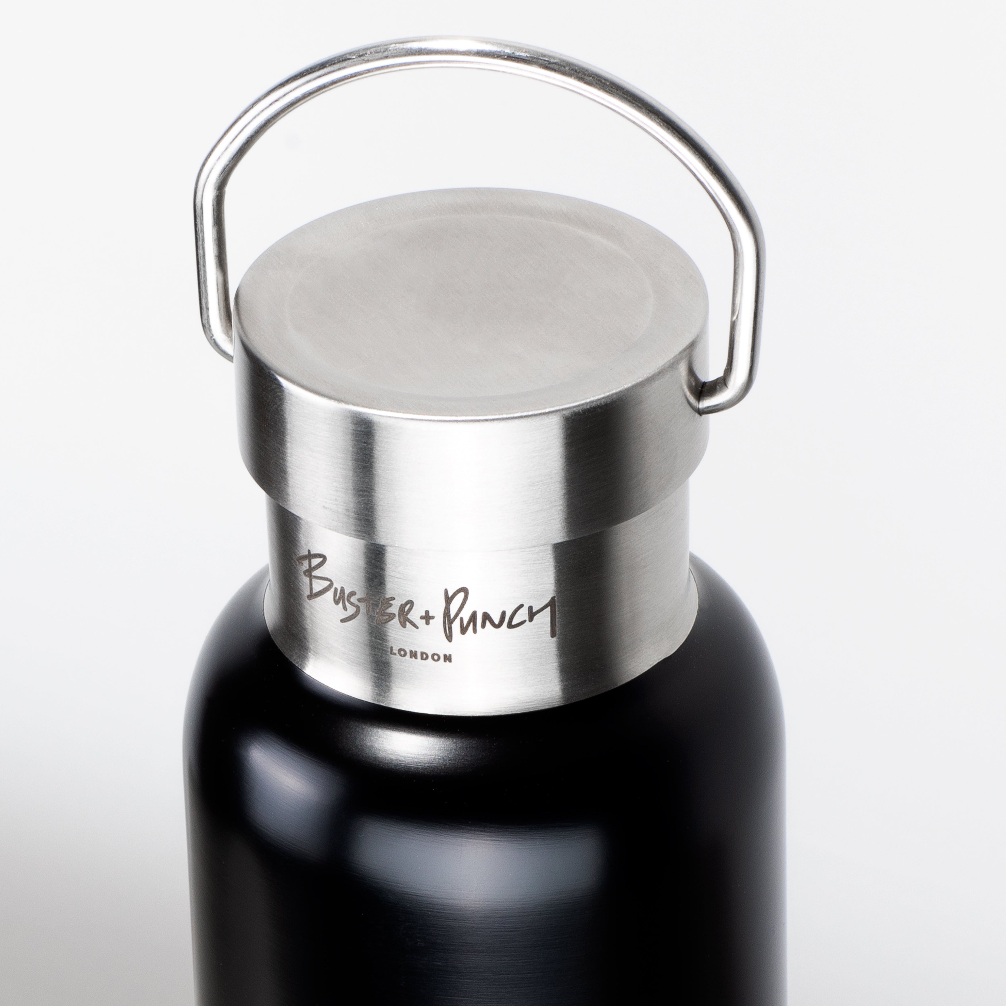 Drikkedunk i sort og rustfri stål med hank, skruelåg og med Buster + Punch logo.