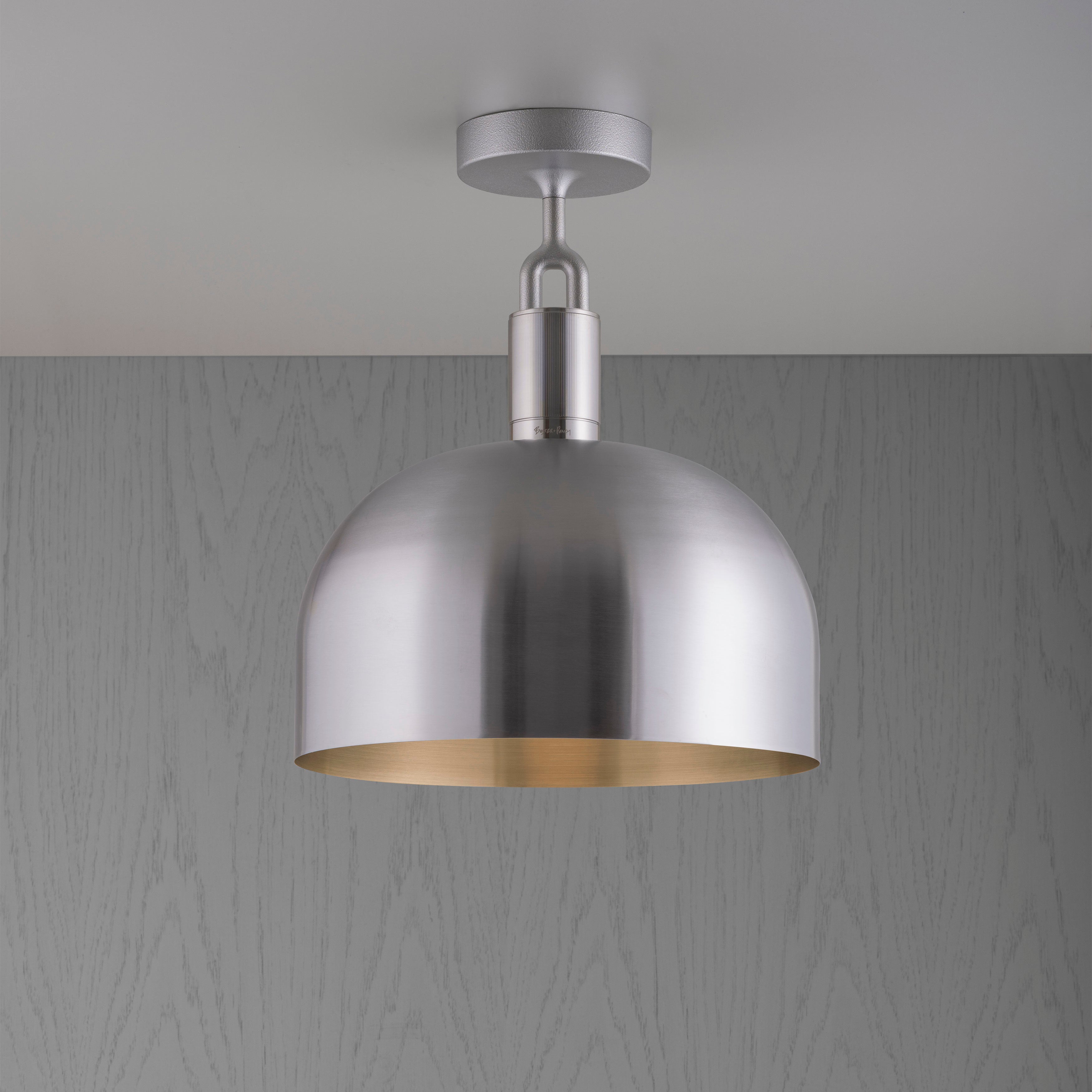 Loftlampe med fatning og skærm af stål, på grå baggrund.