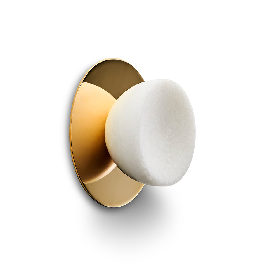 Rund konisk møbelknop i massiv hvid marmor. Her ses knoppen med den runde messing bagplade, som kan tilkøbes til knoppen.