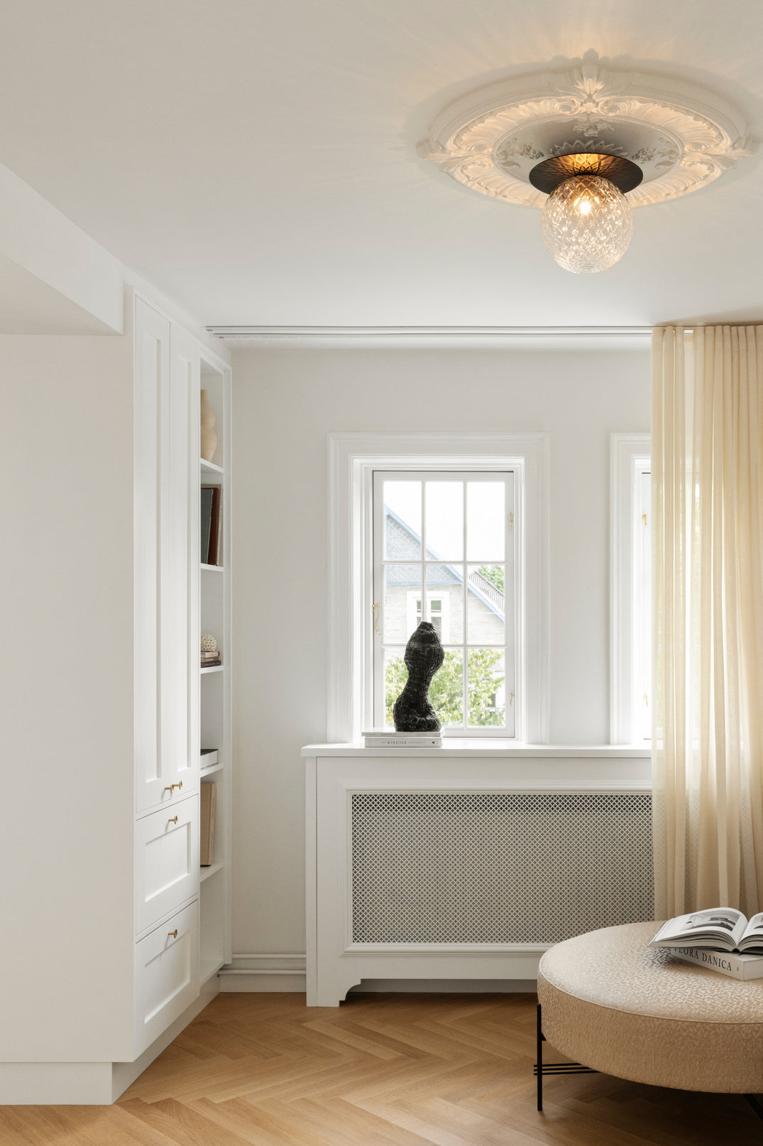 Loftlampe med lampeskærm af klart optikglas og gylden fatning, hængende i stuk roset