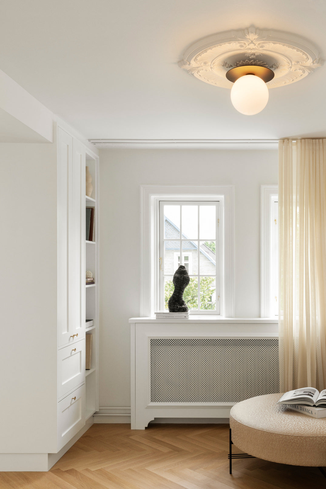 Loftlampe med lampeskærme af opalglas og gylden fatning, i dagligstuemiljø