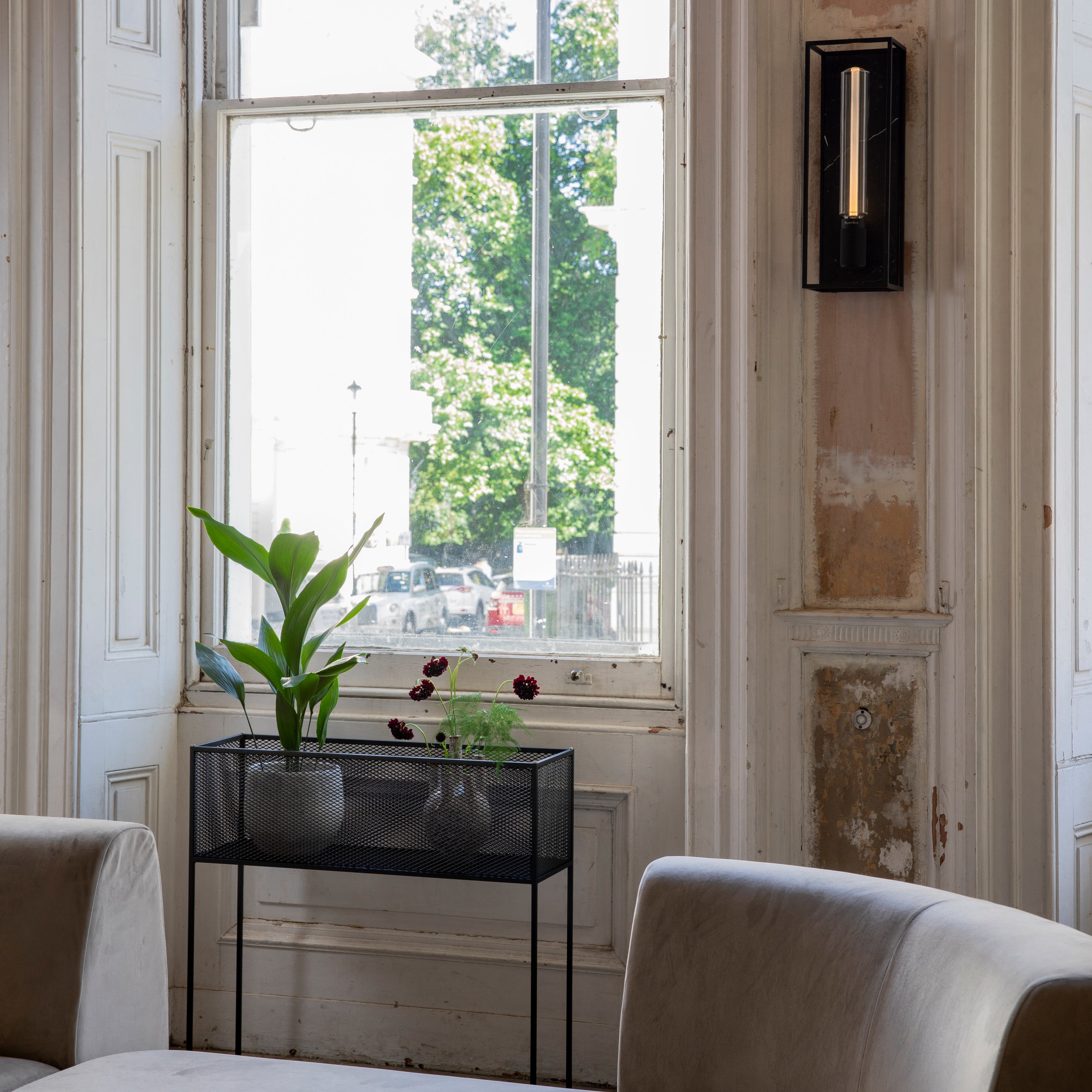 Firkantet og sort plantekasse i stålramme med meshed/hullet design på siderne. Der medfølger detaljer/skruer i både stål og messing.