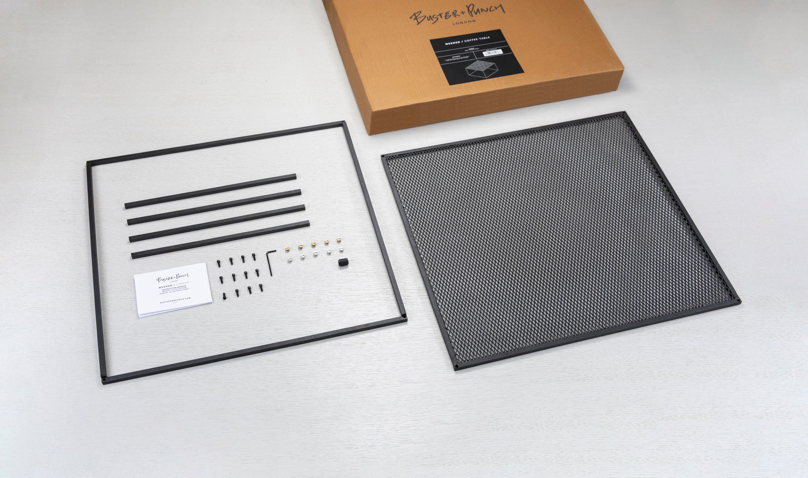 Firkantet sort sofabord med bordplade i meshed/hullet mønster. Vælg mellem detaljer/skruer i messing eller stål (medfølger).