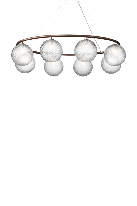 Lysekrone bestående af otte runde skærme i klart optikglas samt bruneret krone, på hvid baggrund