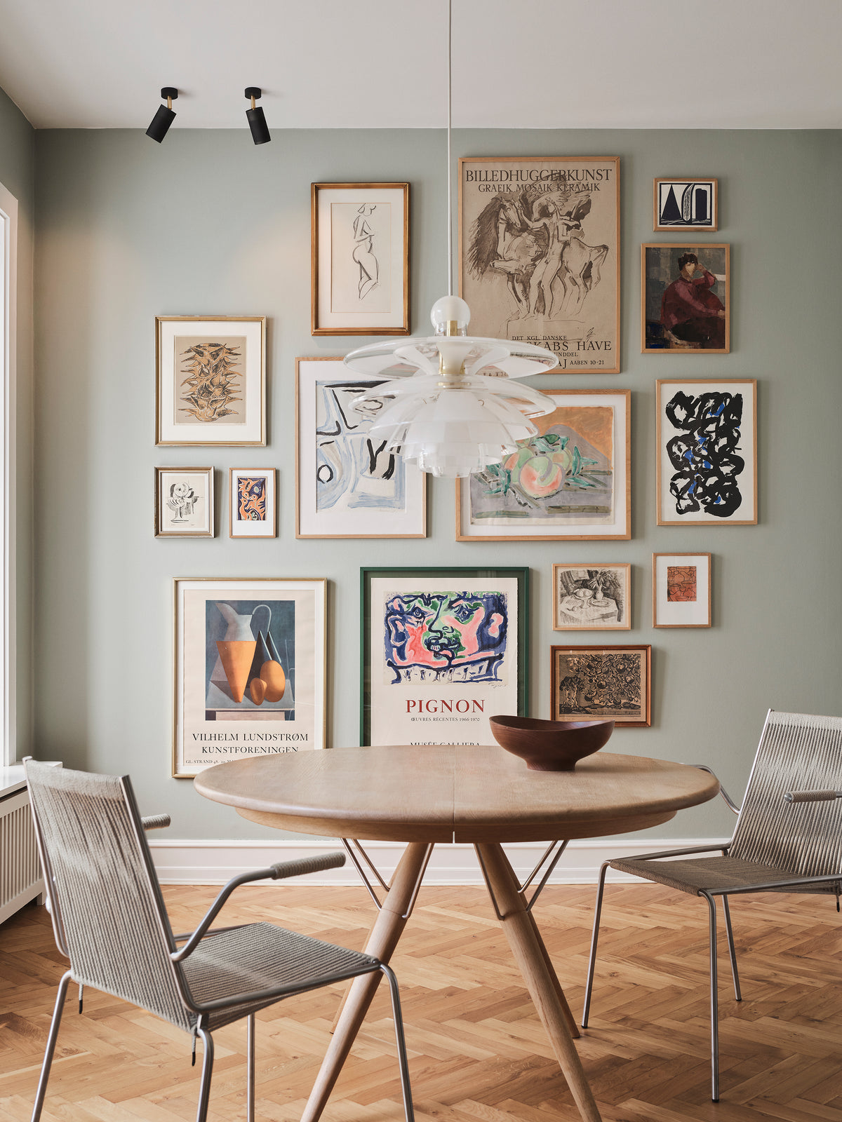 Esszimmer mit Tisch und Stühlen, in dem Deckenstrahler Kunst an der Wand beleuchten