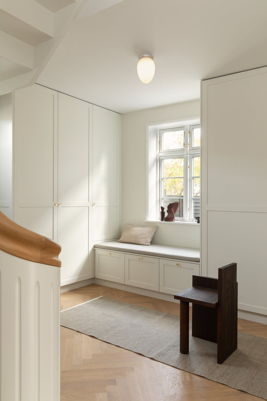 Loftlampe med sølvfarvet fatning og skærm af opalglas, i hall