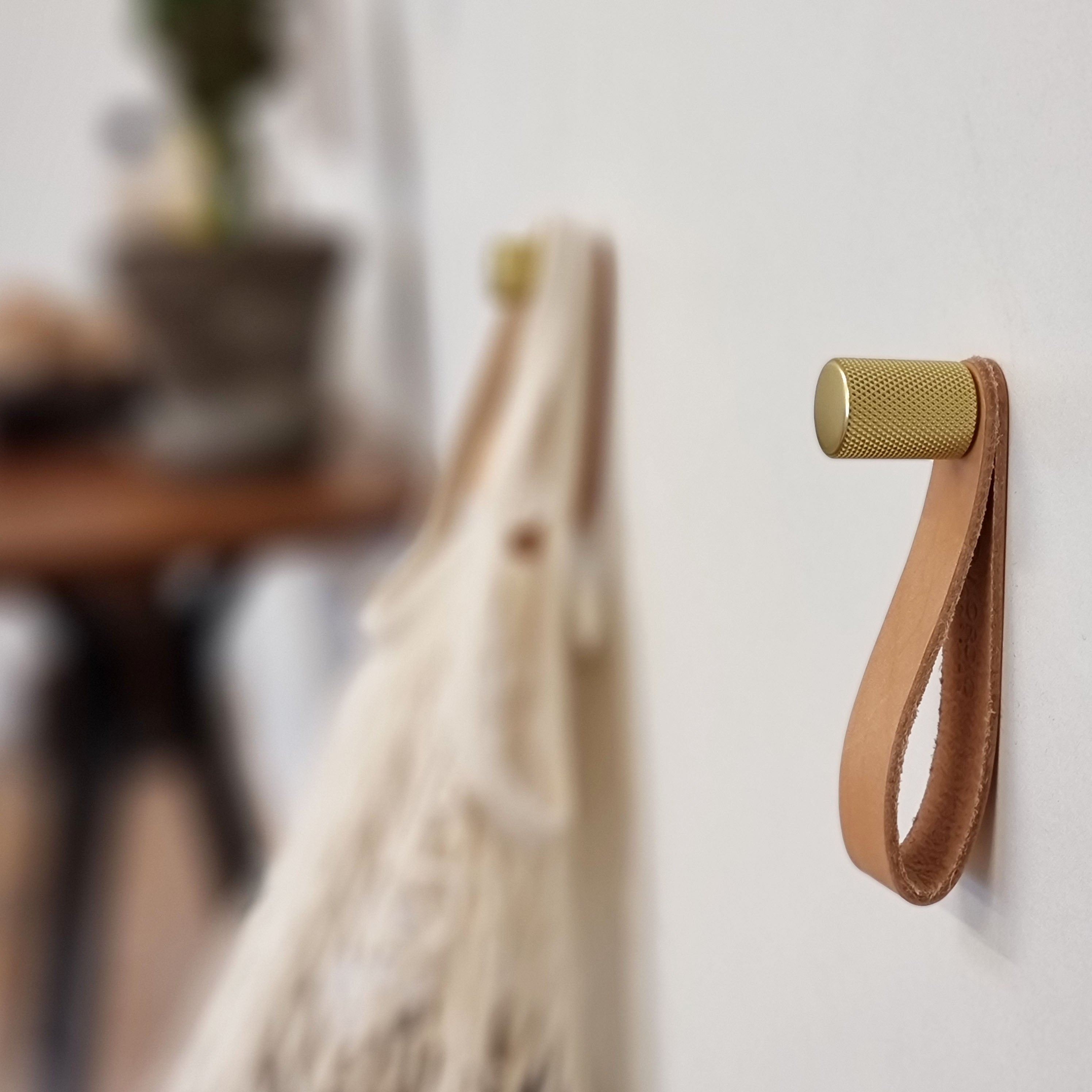 To knager i messing overflade med diamond cut mønster og en naturfarvet læderstrop.