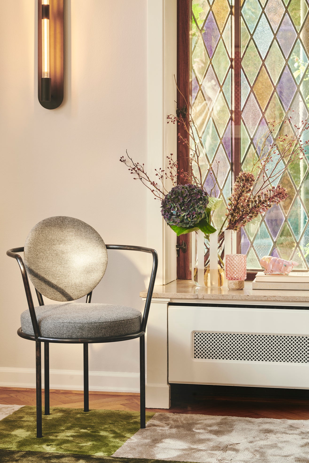 Fyrfadstage med brun marmor bund og en top i rosafarvet glas med mønster.