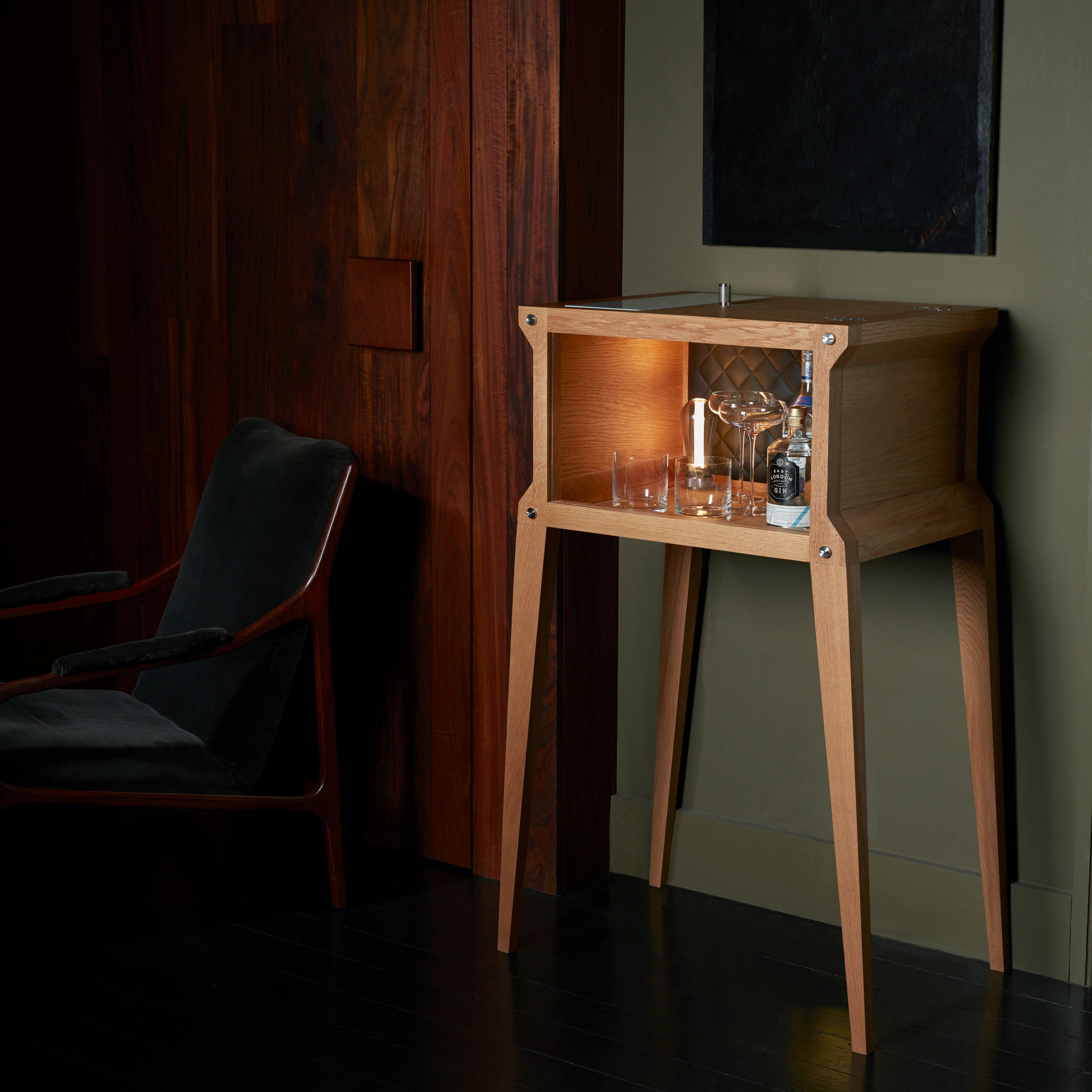 Bar i eg med høje ben, bordplade i hvidmarmor og integreret lyskilde.