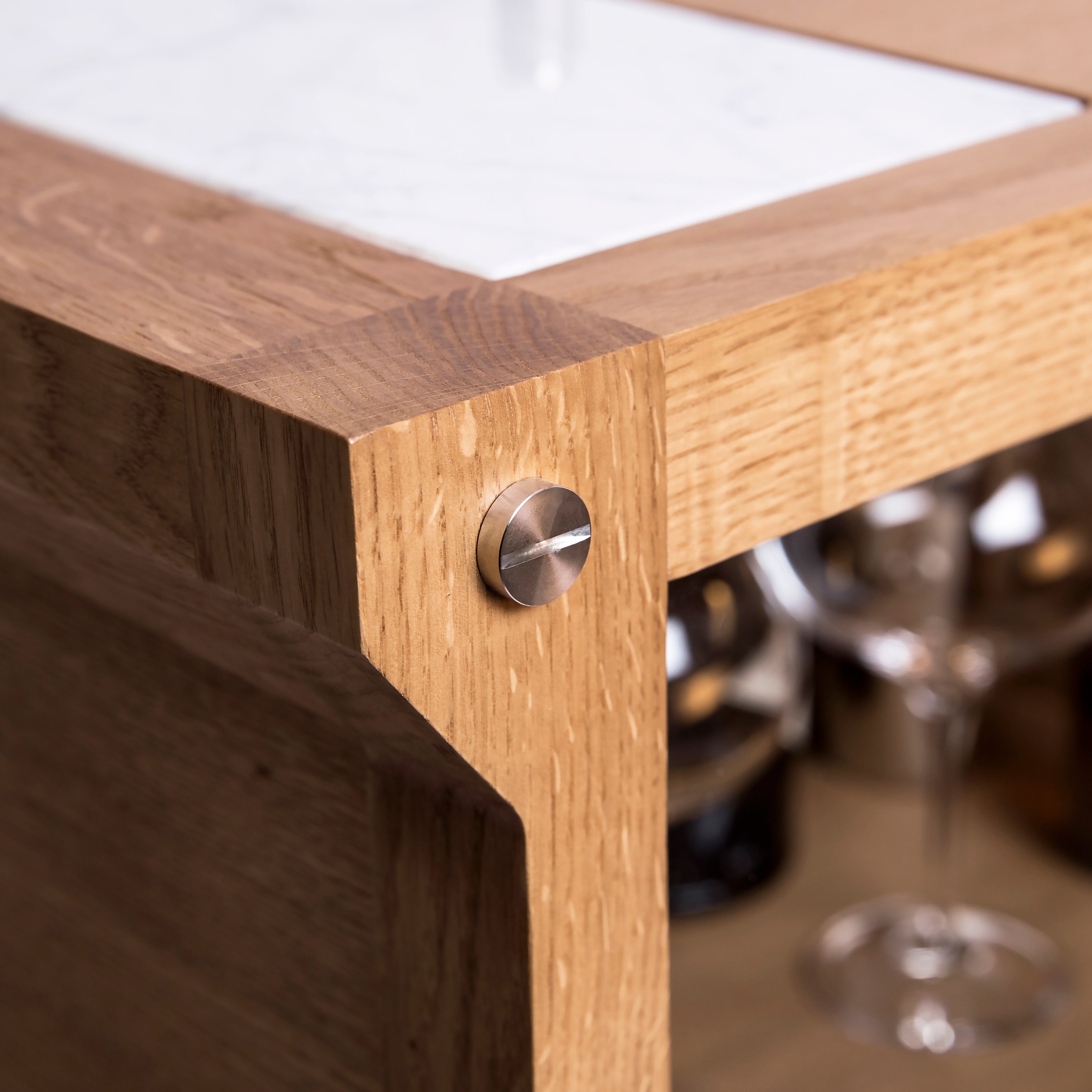 Bar i eg med høje ben, bordplade i hvidmarmor og integreret lyskilde.