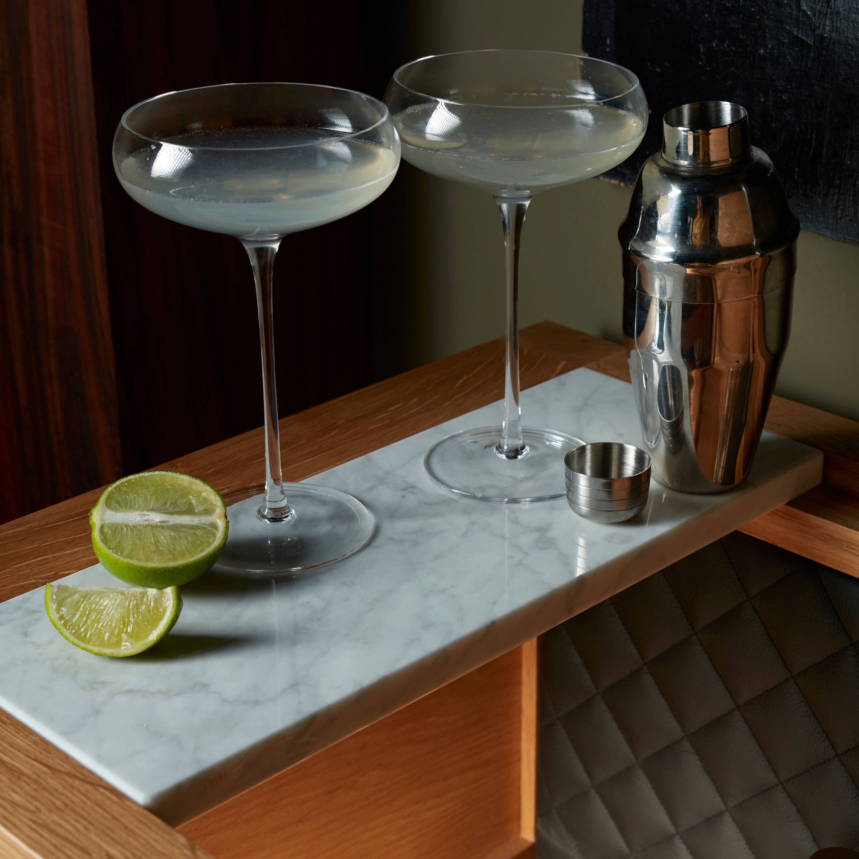 Bar i eg med høje ben, bordplade i hvidmarmor og integreret lyskilde.