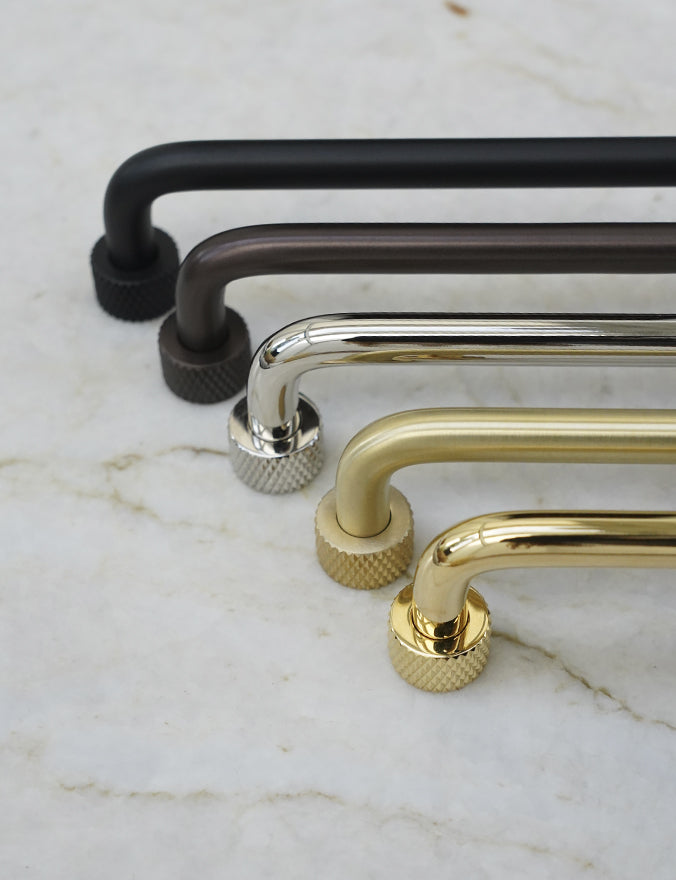 Køkkengreb i messing med en overflade i blank krom. Grebet har runde fødder med riflet diamond cut mønster, som matcher til quooker armatur.