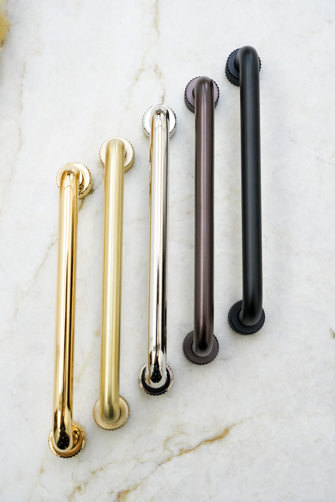 Køkkengreb i massiv messing med en mat sort overflade. Grebet har runde fødder med riflet diamond cut mønster, som matcher til quooker armatur.