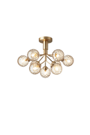 Lysekrone bestående af runde skærme i gyldent optikglas samt messingfarvet krone, på hvid baggrund