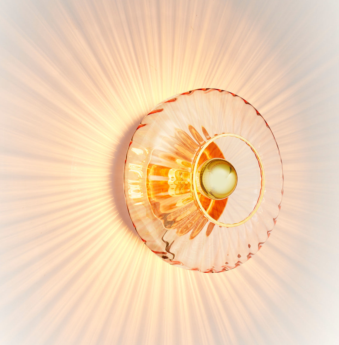 Klar pære med en guld topforsegling monteret i New Wave væglampen fra Design by Us.