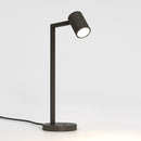 Bronzefarvet bordlampe med justerbar hoved. Lampen har et enkelt design med firkantede linjer/vinkler.