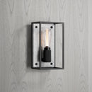 Buster and Punch caged wall lamp medium i sort metal med bagpanel i hvid marmor.