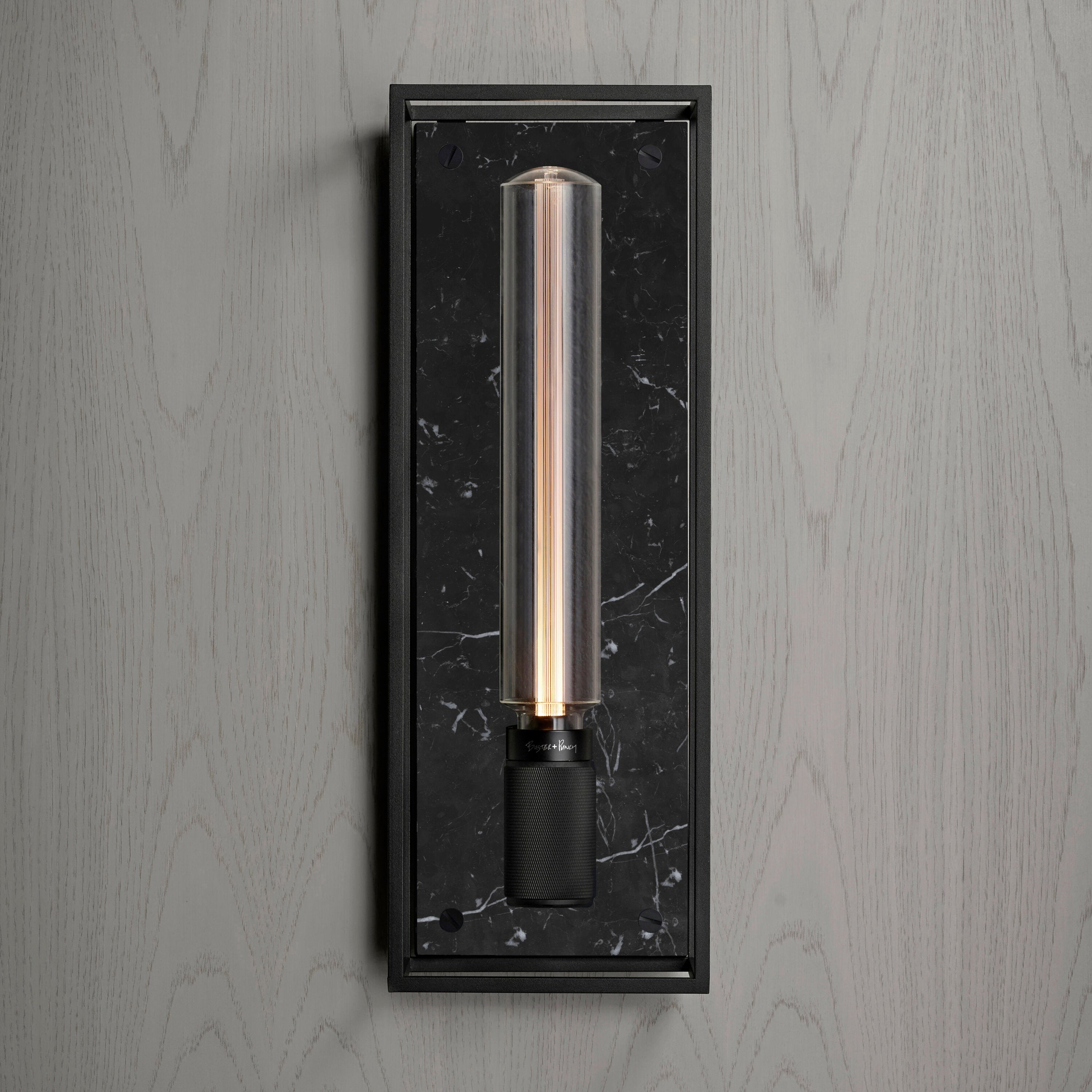 Buster and Punch caged wall lamp large i sort metal med bagplade i sort marmor.