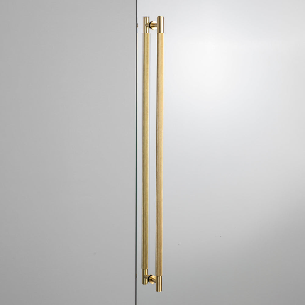Langt dobbeltsidet dørgreb fra Buster + Punch i massiv messing med diamond cut (cross) mønster. Kan bl.a. anvendes som greb til sving- og skydedøre.