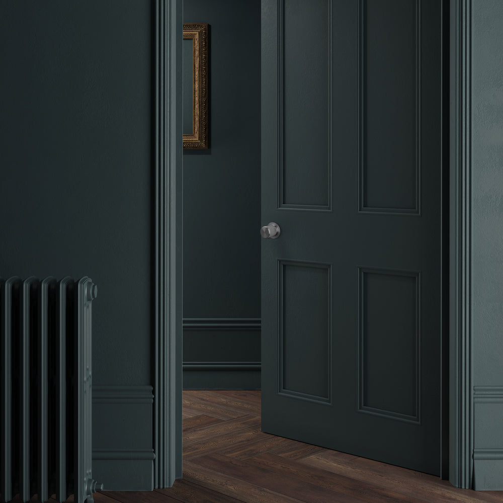 Eksklusiv dørknop i rustfri stål med linjeret mønster. Her ses dørknoppen monteret på en grøn dør.