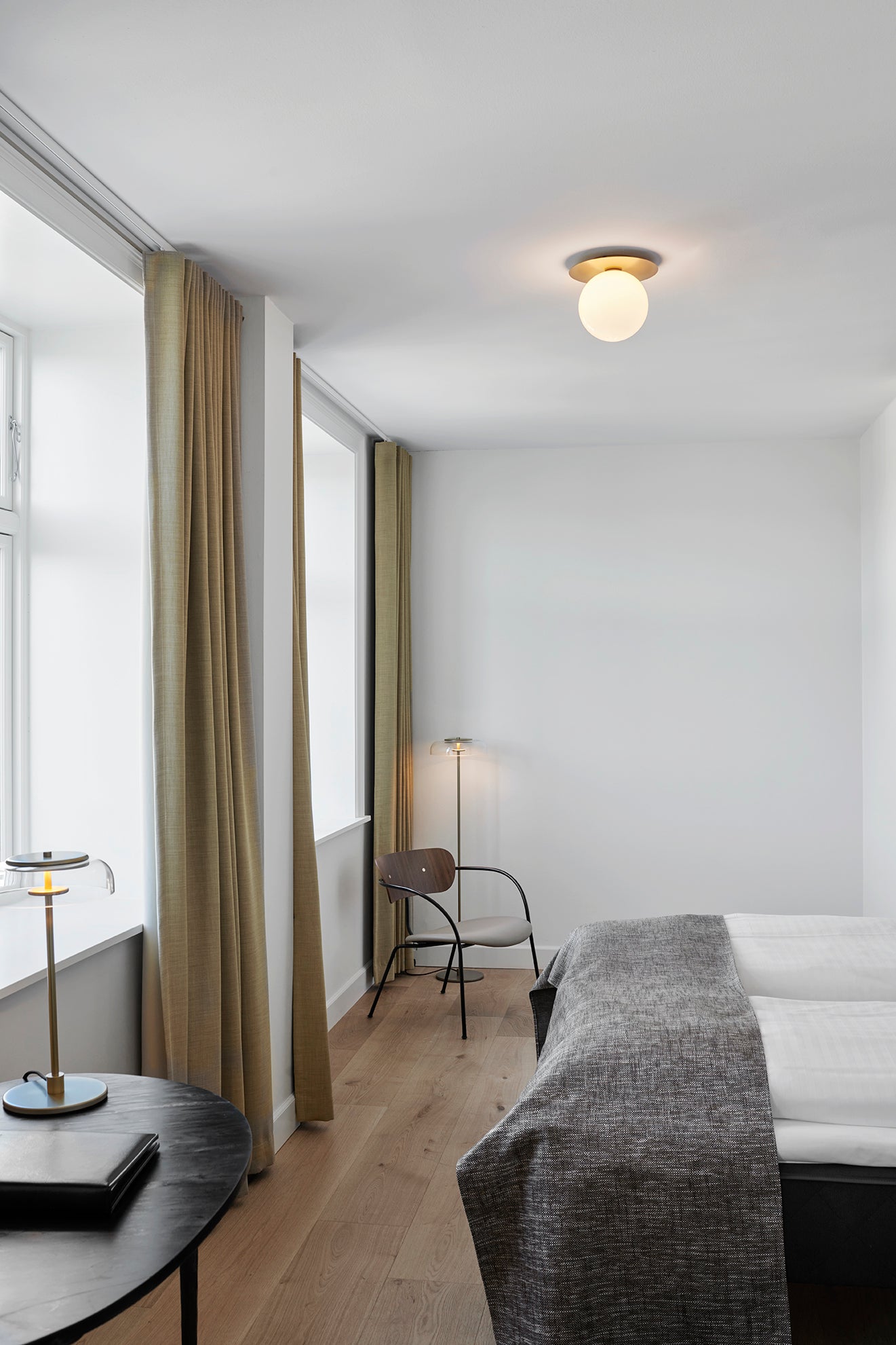 Loftlampe med lampeskærme af opalglas og gylden fatning, i dagligstuemiljø