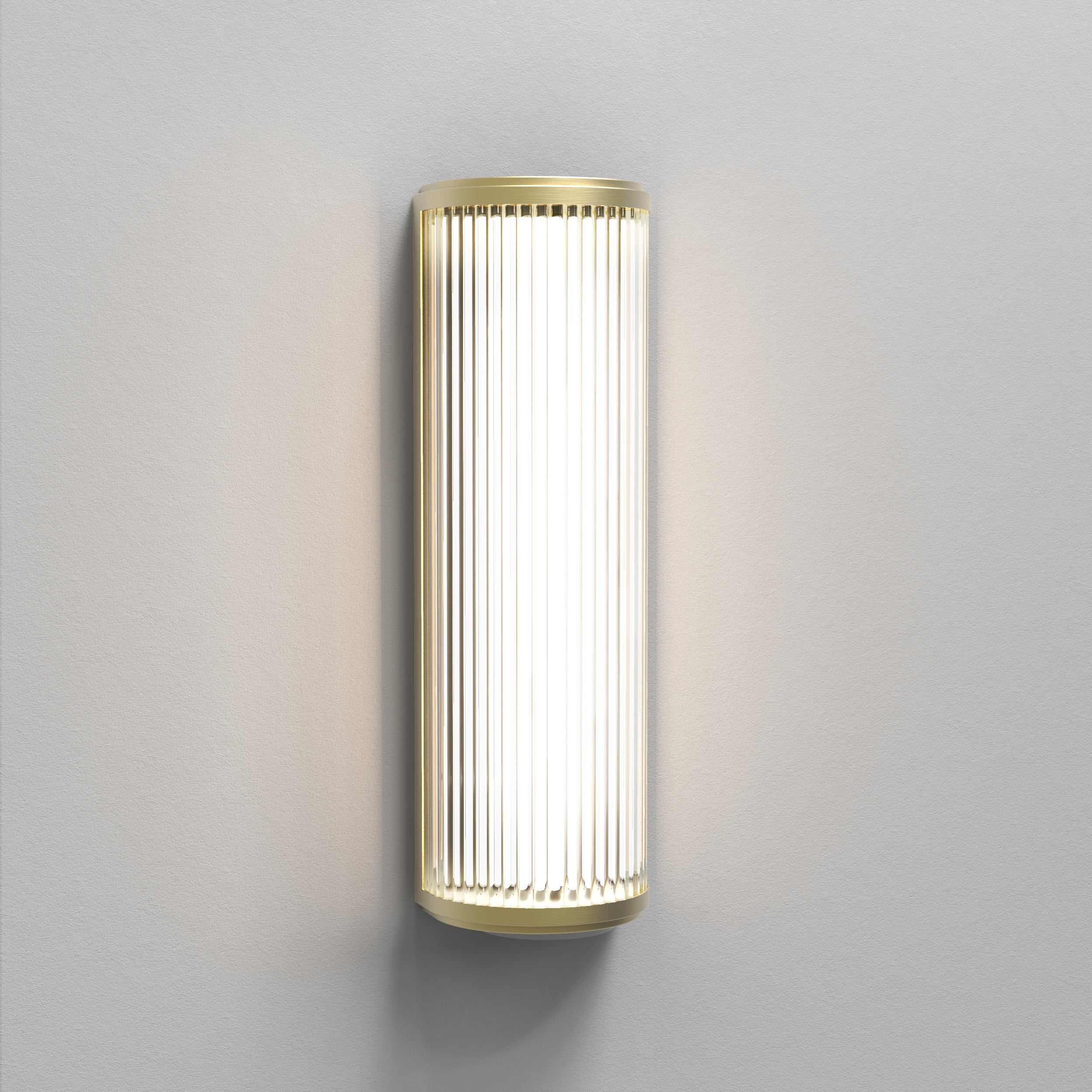 Aflang væglampe med top, bund og bagside i guldfarvet stål samt en glaskærm med linjer.